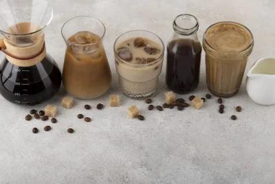 Five coffees, a brewer with 400 ml mark, creamer pitcher, sugar cubes, and scattered coffee beans.