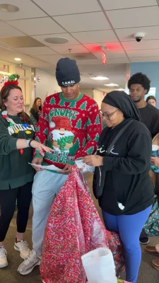 Jalen Coker with hospital staff and donated gifts at a holiday charity event.