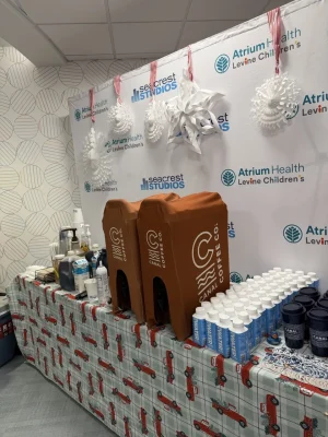 Canal Coffee beverage station with dispensers, bottled water, and branded cups at an Atrium Health event.