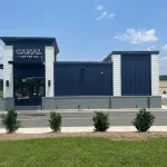 Exterior of Canal Coffee Co. with blue and white building, storefront, and landscaped shrubs.