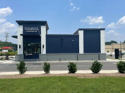 Exterior of Canal Coffee Co. with blue and white building, storefront, and landscaped shrubs.