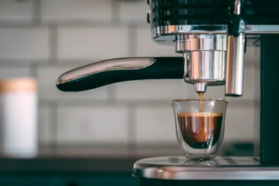 Espresso pouring from a machine into a small glass cup.