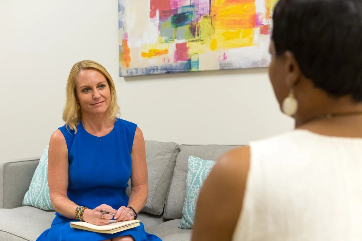 Woman taking notes during a one-on-one consultation.